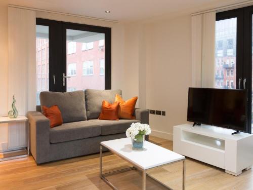a living room with a couch and a tv at Central Tower Bridge Apartment in London