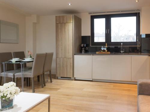 a living room with a kitchen and a table with chairs at Central Tower Bridge Apartment in London