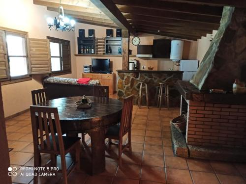 eine Küche und ein Wohnzimmer mit einem Tisch und einem Kamin in der Unterkunft Casa Penelas in Petín
