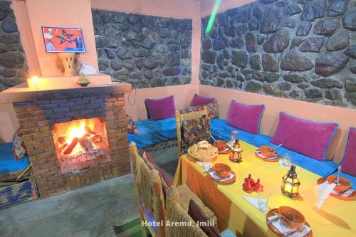 a dining room with a fireplace and a table with food at Hotel Aremd - Aroumd Imlil route du Toubkal in Imlil