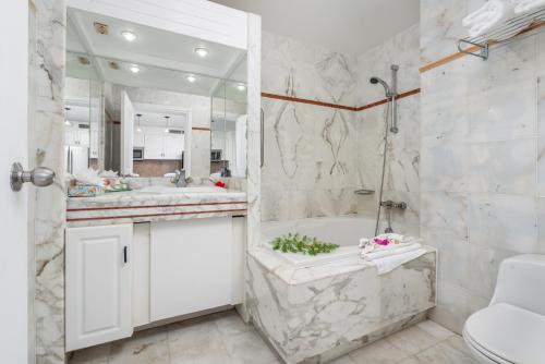 y baño con 2 lavabos, bañera y ducha. en Sint Maarten Blue Dream Studio 6, en Cupecoy