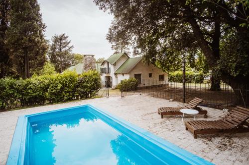 a swimming pool in front of a house at La Verbena in Sierra de la Ventana