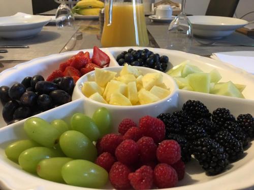 a plate of fruit on a table with bowls of fruits at Prestbury Bed & Breakfast in Salisbury