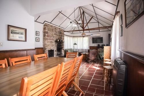 Un comedor con una gran mesa y sillas de madera. en La Verbena, en Sierra de la Ventana