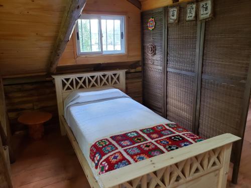 a small bedroom with a bed in a cabin at Cabaña El Refugio in Open Door