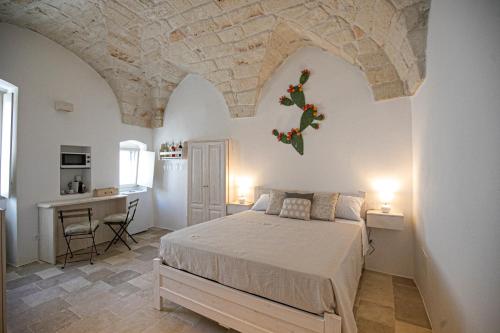 1 dormitorio con 1 cama y escritorio en una habitación en Radici Ostuni en Ostuni