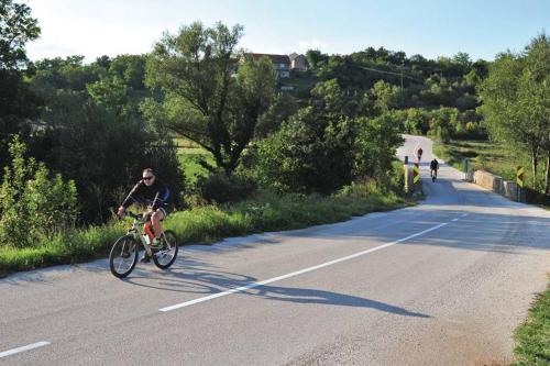 a man riding a bike down a road at Villa Lana in Crivac