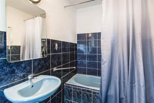 a bathroom with a sink and a tub and a shower curtain at Villa Lana in Crivac
