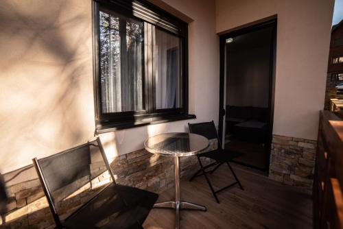 a small table and two chairs in a room with a window at Apartman Rada in Zlatibor