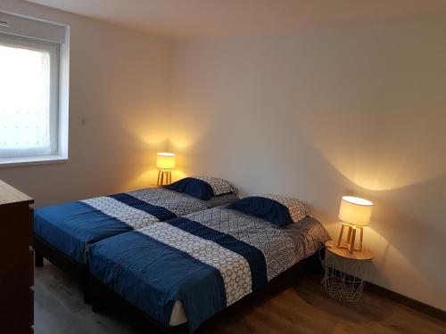 a bedroom with a bed with two lamps on it at appart Hérisson RDC accessible PMR in Cornimont