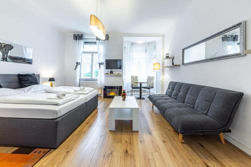 ein Wohnzimmer mit einem Bett und einem Sofa in der Unterkunft CHRISTIANO Apartments - Villa Schönbrunn in Wien