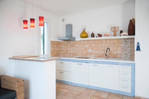 a kitchen with white cabinets and a sink at Residence Quattrocolonne in Santa Maria al Bagno