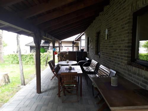 a patio with a table and chairs and a brick wall at Heuerhaus Gut Einhaus in Werlte