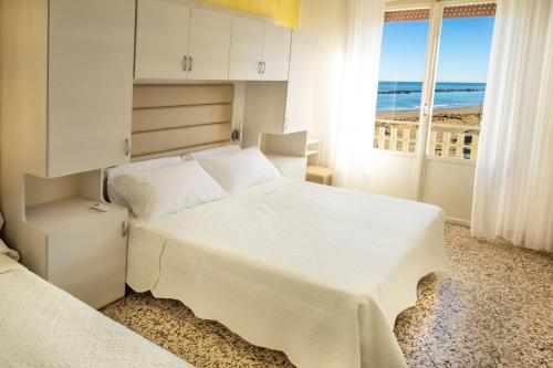 a bedroom with a large white bed and a window at Hotel Villa Sole Resort in Bellaria-Igea Marina