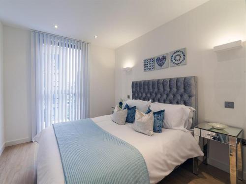 a bedroom with a large bed with a blue headboard at Exclusive Tower Bridge Apartment in London