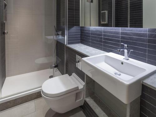 a bathroom with a white toilet and a sink at Exclusive Tower Bridge Apartment in London