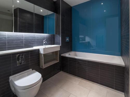 a bathroom with a toilet and a sink and a tub at Exclusive Tower Bridge Apartment in London
