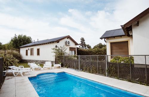 una piscina en un patio trasero con una casa en Cabañas Sol Serrano en Sierra de la Ventana