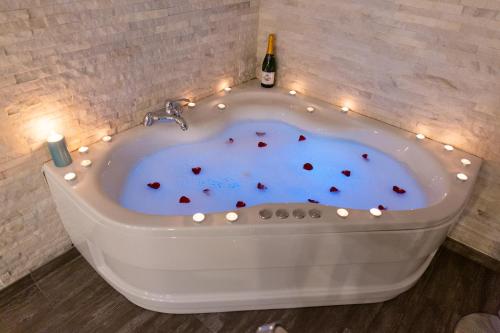 a hot tub with candles and a bottle of wine at SPA Apartment Nalis in Niš