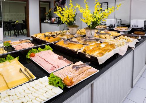a buffet line with many different types of food at Hotel Rosenbrock in Balneário Camboriú