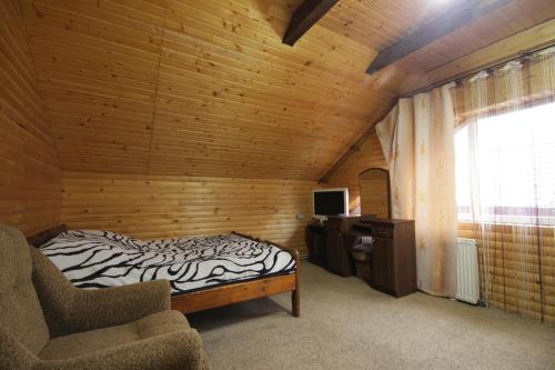 マイコリチンにあるВиноградна лозаのベッド1台、椅子、窓が備わる客室です。