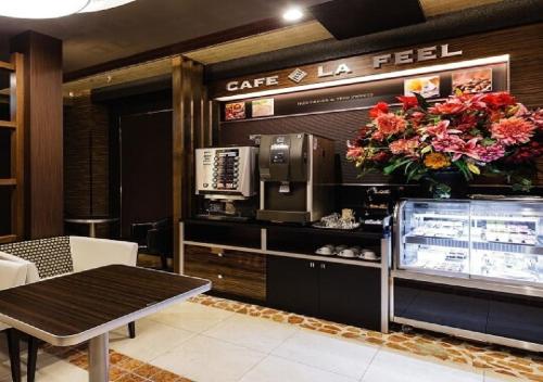un ristorante con caffetteria la feel con tavolo e fiori di Hotel Feel / Vacation STAY 63703 a Yokohama