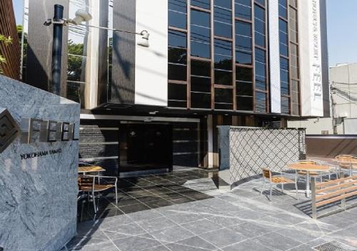 a patio with tables and chairs in front of a building at Hotel Feel / Vacation STAY 63703 in Yokohama