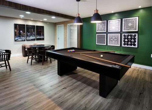 a pool table in a room with green walls at Hotel Rosenbrock in Balneário Camboriú