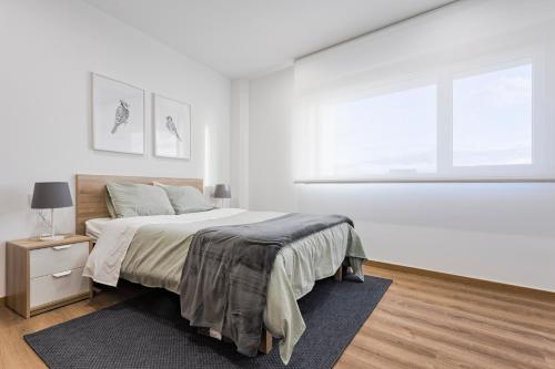 ein weißes Schlafzimmer mit einem Bett und einem Fenster in der Unterkunft APARTAMENTO LUMINOSO EN CANGAS - A in Cangas