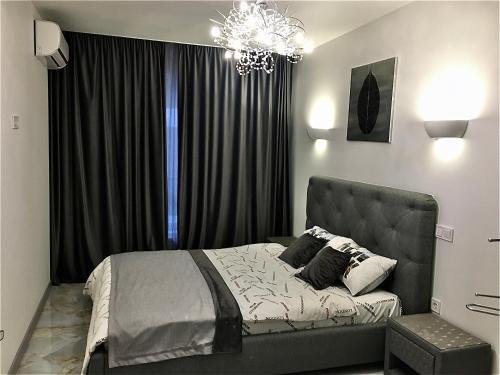 Un dormitorio con una cama grande y una lámpara de araña. en 4-room jacuzzi apartment, en Leópolis