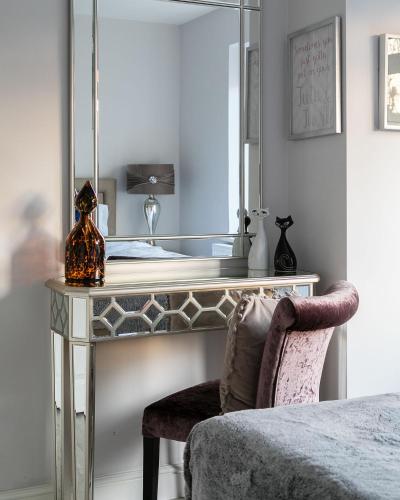 a dressing table with a mirror and a chair at Cromwell road apartments in London