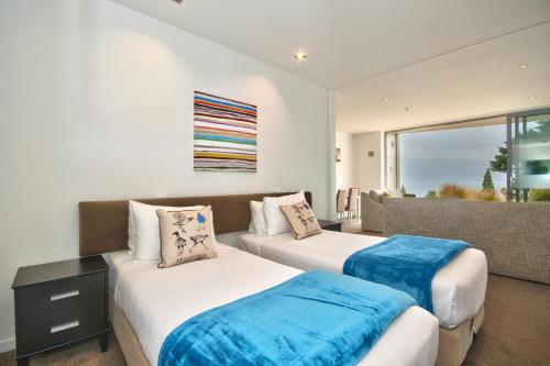 a bedroom with two beds and a couch at Lakes Edge Apartment in Queenstown