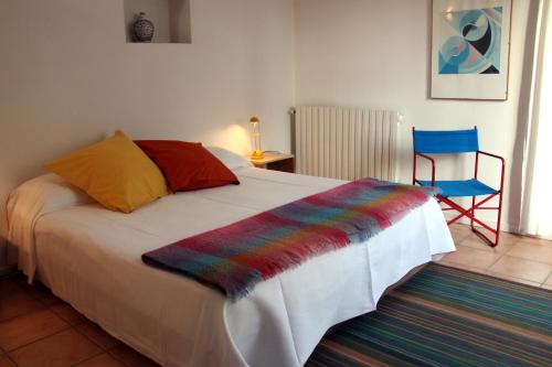 ein Schlafzimmer mit einem Bett und einem blauen Stuhl in der Unterkunft Paradix holiday apartment - gîte 4, 2 pers in Nissan-lez-Enserune