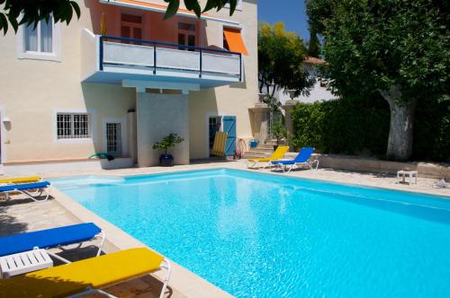 einen Pool mit Stühlen und ein Haus in der Unterkunft Paradix holiday apartment - gîte 4, 2 pers in Nissan-lez-Enserune