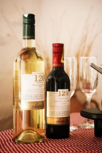 two bottles of wine sitting on a table with glasses at Hotel Casa del Marquez de Bahichala in Barichara