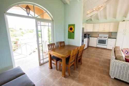 a kitchen with a wooden table and chairs in a room at Casa di Bon Bientu in Kralendijk