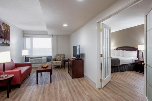 a hotel room with a bed and a living room at Viscount Gort Hotel, Banquet & Conference Centre in Winnipeg