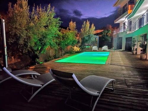 a swimming pool with chairs in front of a house at Vilaportuguesa in Vila Velha de Ródão