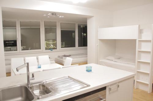 a kitchen with a sink and a living room at Hauptbahnhof S2 in Vienna