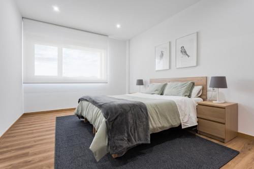 A bed or beds in a room at APARTAMENTO LUMINOSO EN CANGAS - B