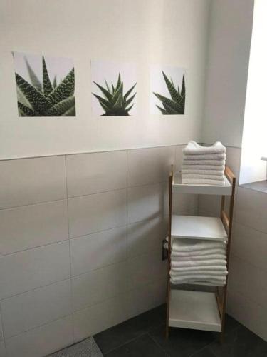 a bathroom with three pictures of plants on the wall at Apartment Peotta in Volders