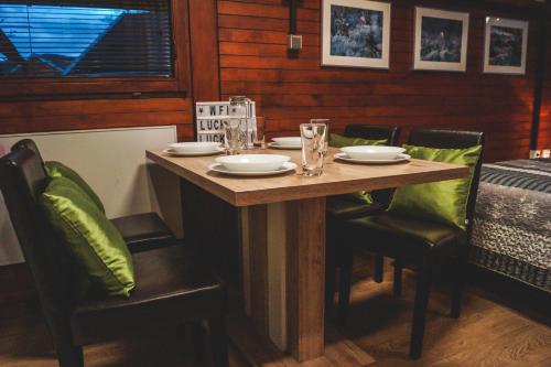 uma mesa de madeira com cadeiras, pratos e copos em Lucky home em Catez ob Savi