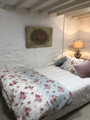 a bedroom with a bed with a floral comforter at Bluebell Cottage in Kilmore Quay