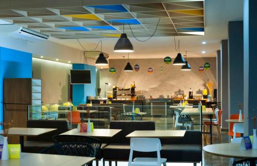 um restaurante com mesas e cadeiras e uma cafetaria em B&B HOTEL Uberlândia em Uberlândia