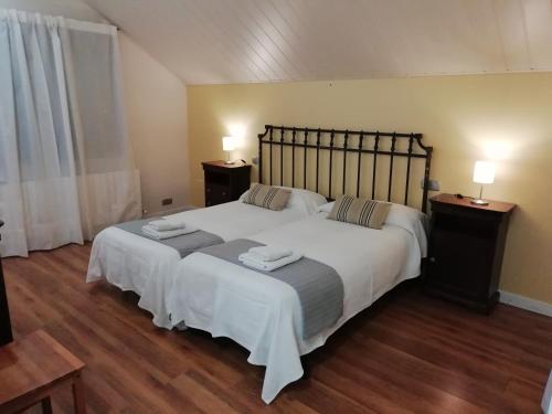 a bedroom with a large white bed with two night stands at VillaTerreno Casa Rural en Logroño in Villamediana de Iregua