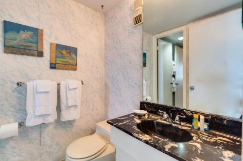 オーシャンシティにあるGolden Sandsの洗面台、トイレ、鏡のあるバスルーム