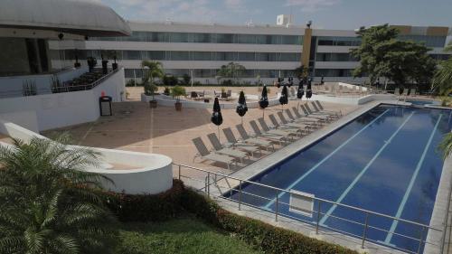 a swimming pool with lounge chairs and a building at Holiday Inn - Villahermosa Aeropuerto by IHG in Villahermosa
