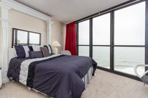 オーシャンシティにあるGolden Sandsのベッドと大きな窓のある寝室