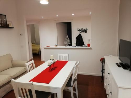 una cucina e un soggiorno con tavolo bianco con panno rosso di Davide & Mary friendly house a Novara