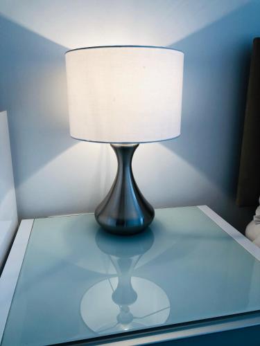 a lamp sitting on top of a glass table at Luxury Lodge Excel London in Moffat